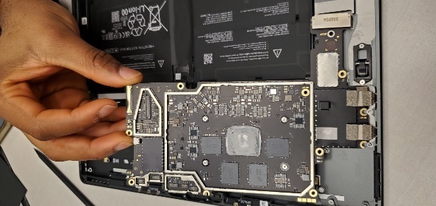 Screenshot that shows motherboard being tilted left and lifted clear of enclosure with USB ports freed.